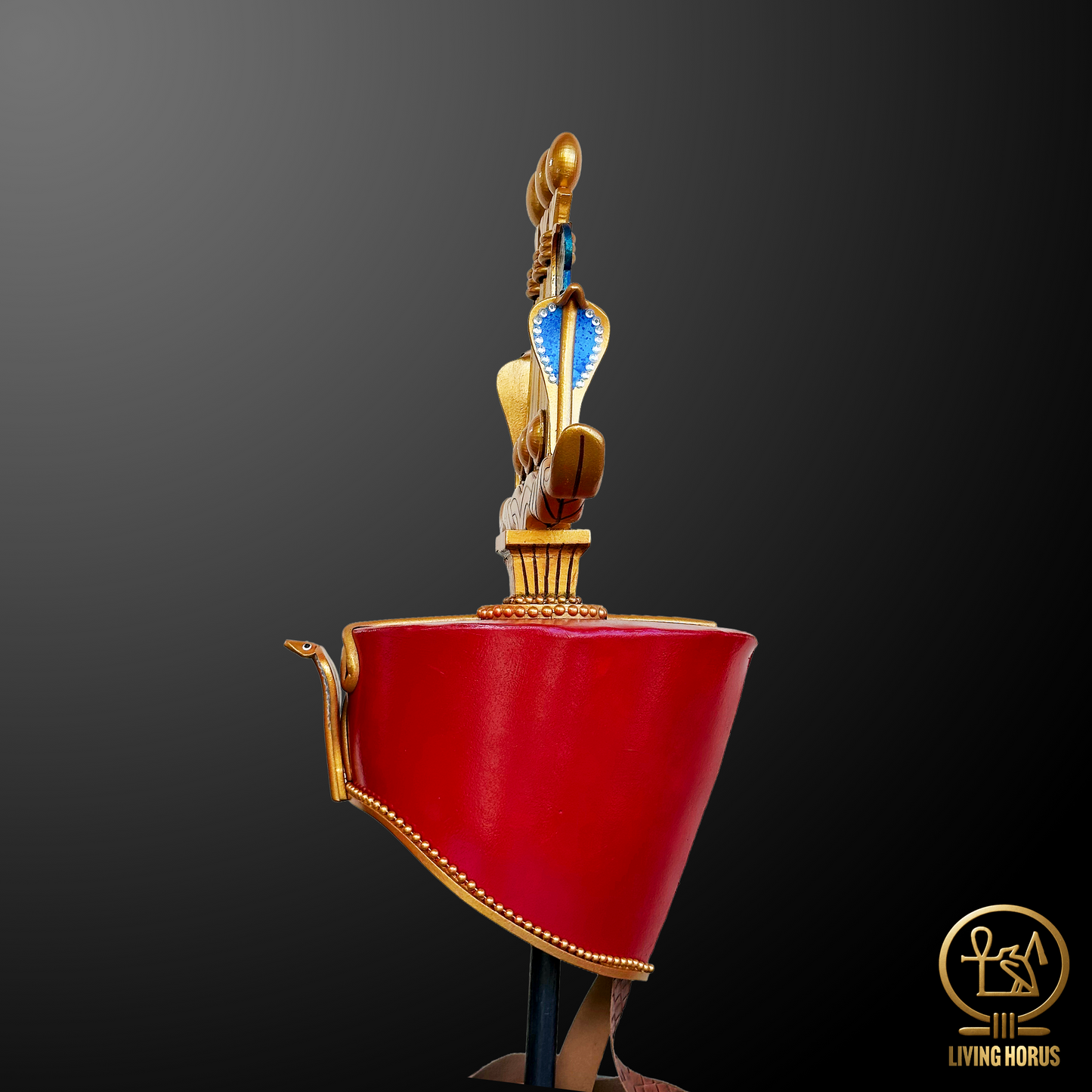 Red crown with gold and blue decorative elements on a dark background