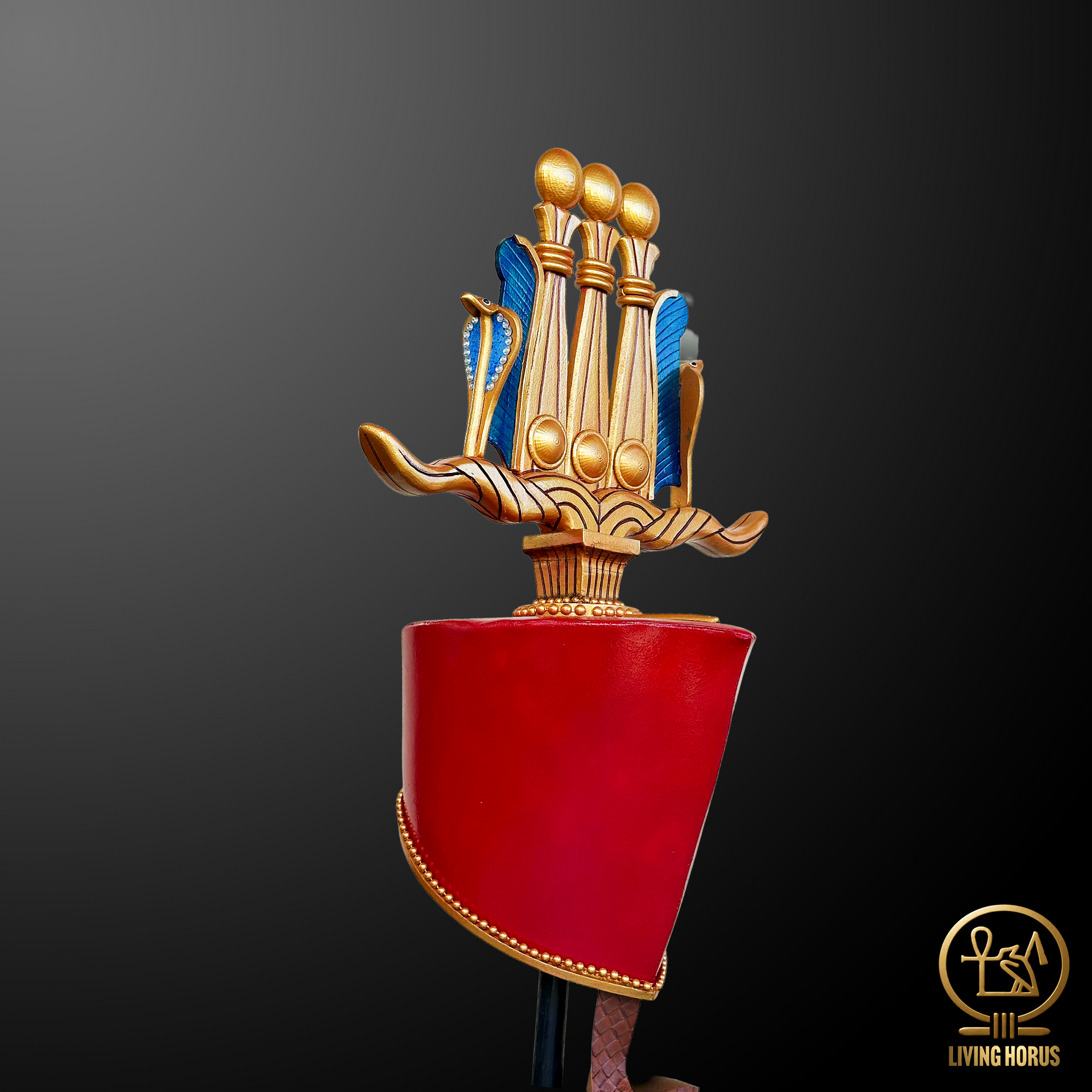 Decorative object with gold and blue elements on a red base against a dark background